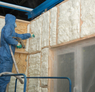 The worker insulates the walls of the house with foam for sound insulation and heat